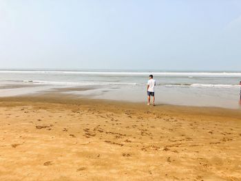 Man standing on beach against sky