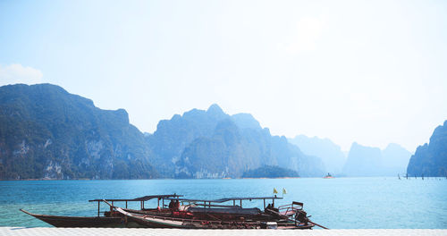 Scenic view of sea and mountains against clear sky