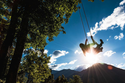 Low angle view of silhouette trees against sky