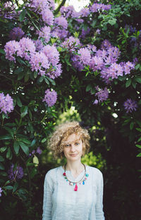 Portrait of woman against purple flowering plants