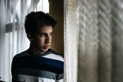 Portrait of young man standing at home