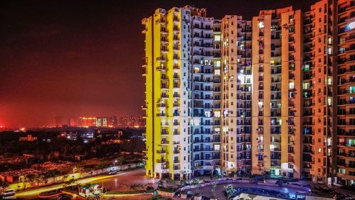 Illuminated buildings against sky at night