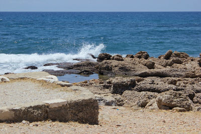 Rocks on beach against clear sky