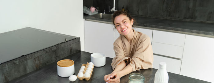 Young woman using mobile phone while sitting on table