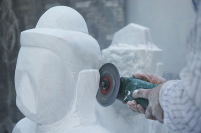 Cropped image of man making buddha statue in workshop