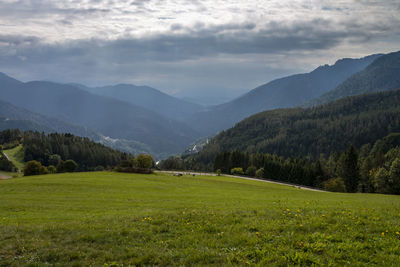 Scenic view of field and mountains against sky