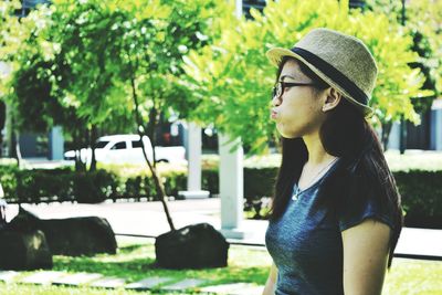 Close-up of woman looking away while making a face in park