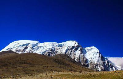 Scenic view of snowcapped mountains against clear blue sky