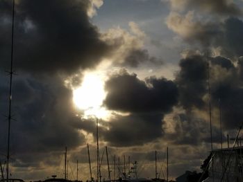 Low angle view of silhouette cranes against sky during sunset