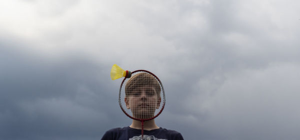 Rear view of woman holding umbrella against sky