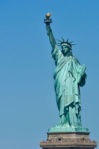 Low angle view of statue against blue sky