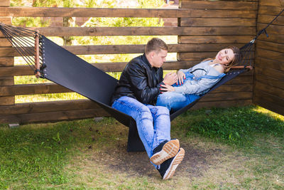 Men sitting on man lying on grass