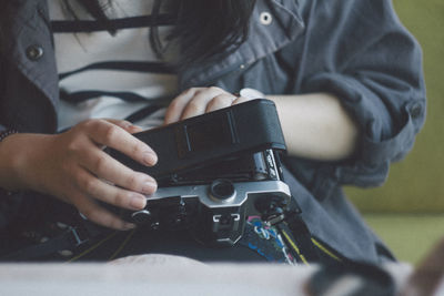 Midsection of woman holding camera