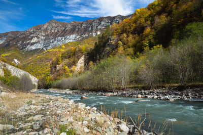 Scenic view of lake by mountains against sky