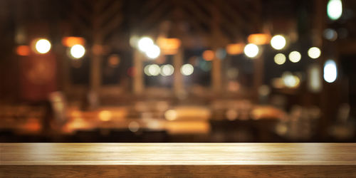 Defocused image of illuminated lights on table in city at night