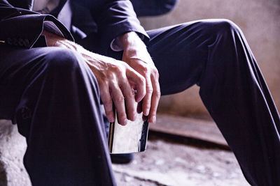 Midsection of man sitting on street