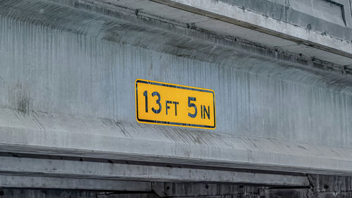 Low angle view of yellow sign on wall