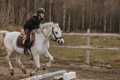 View of girl horseback riding