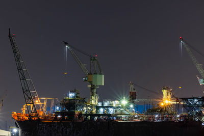 Illuminated commercial dock against clear sky at night