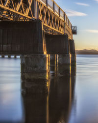 Low angle view of bridge over river against sky