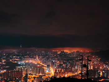High angle view of illuminated cityscape against sky at night