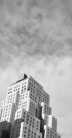 Low angle view of buildings against cloudy sky