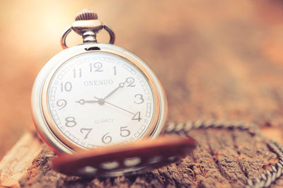 Close-up of pocket watch on wood