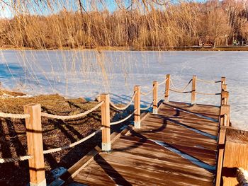 Empty wooden chairs on beach by lake