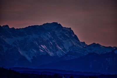 Scenic view of snowcapped mountains against sky at sunset