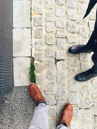 Low section of men standing on footpath