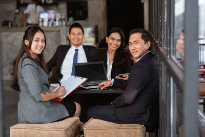 Portrait of smiling businesswoman using laptop at office