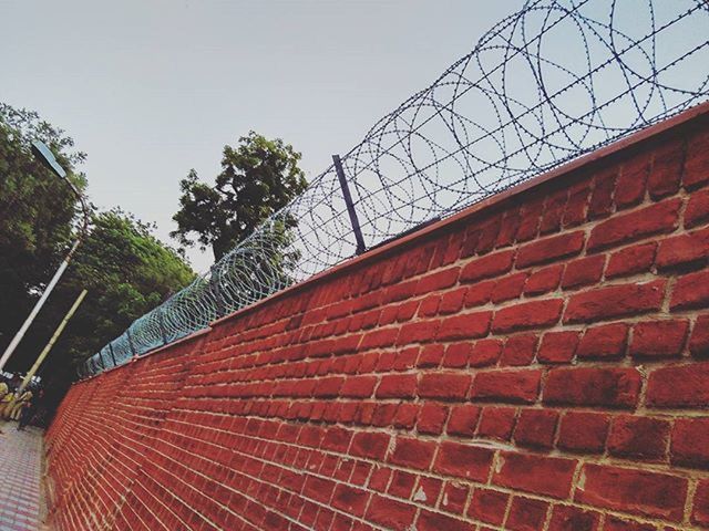 architecture, built structure, building exterior, low angle view, red, brick wall, clear sky, wall - building feature, day, sky, metal, outdoors, no people, building, tree, steps, window, pattern, sunlight, railing