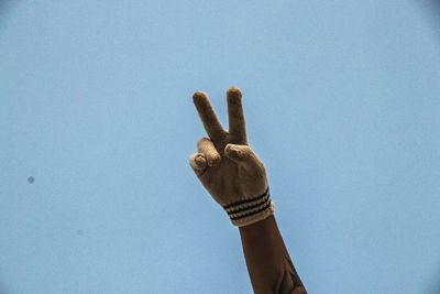 Low angle view of human hand against sky