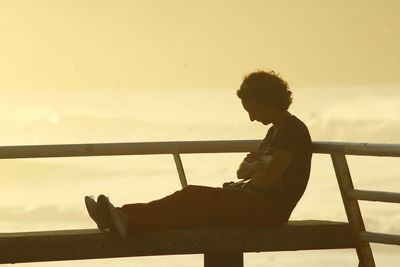 Side view of man sitting on bench