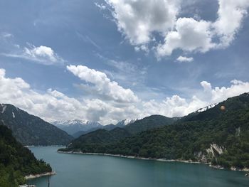 Scenic view of river and mountains against sky