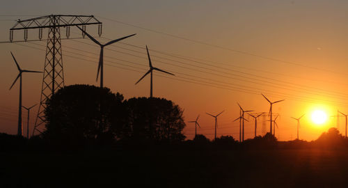 Silhouette windmills during sunset