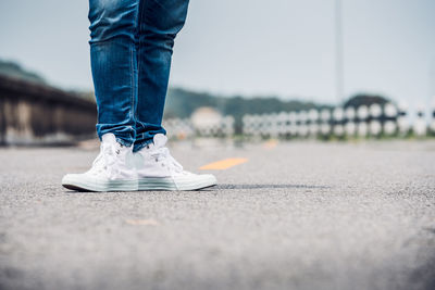 Low section of man standing on road