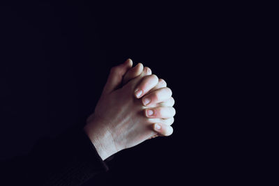 Close-up of human hand against black background