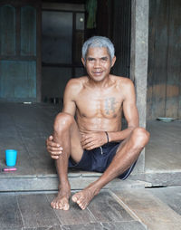 Portrait of shirtless man sitting at home