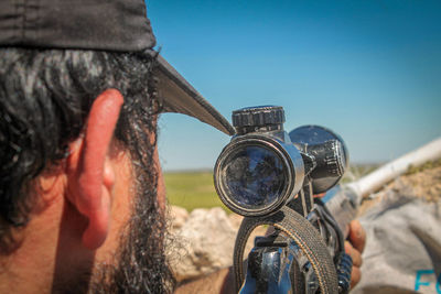 Portrait of man photographing against sky