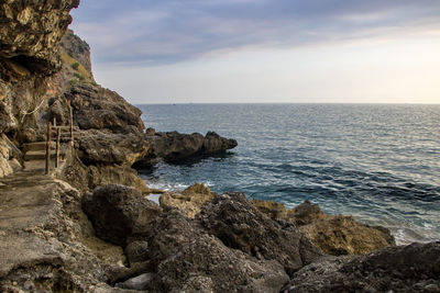 Rocks on sea shore against sky