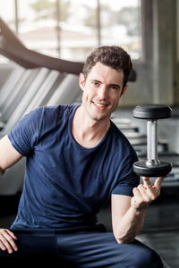 Lifestyle playful man having fun lifting dumbbell in gym exercise with work out program for healthy.