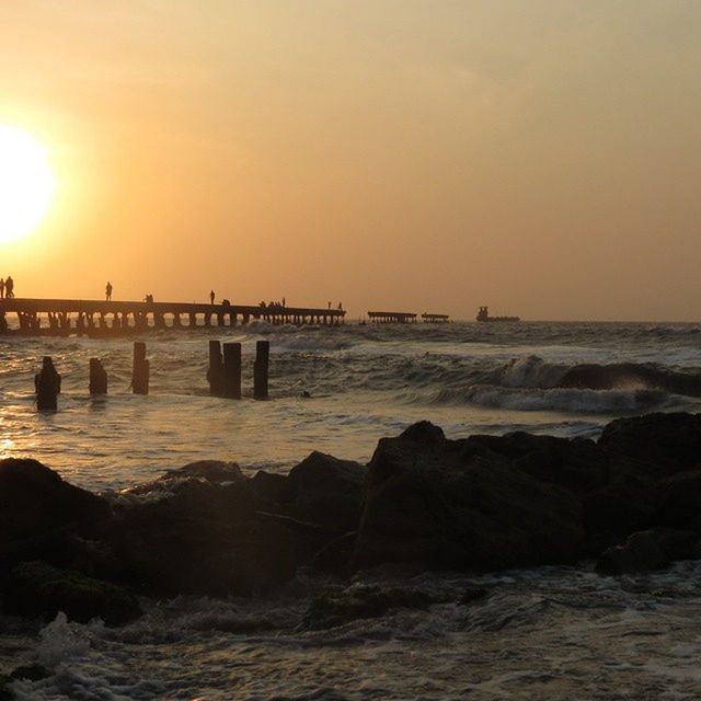 sea, water, sunset, horizon over water, sun, scenics, beauty in nature, tranquil scene, beach, tranquility, wave, sky, shore, pier, nature, idyllic, sunlight, rock - object, silhouette, orange color