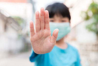 Portrait of boy with hand in background