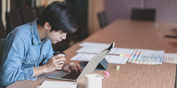 Businessman using laptop on desk in office