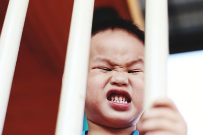 Angry boy seen through railing