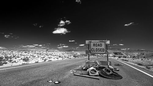 Bicycle sign on road against sky