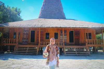 Portrait of woman standing against building