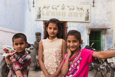 Portrait of happy girl standing against people