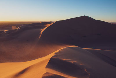 Scenic view of desert against sky during sunset